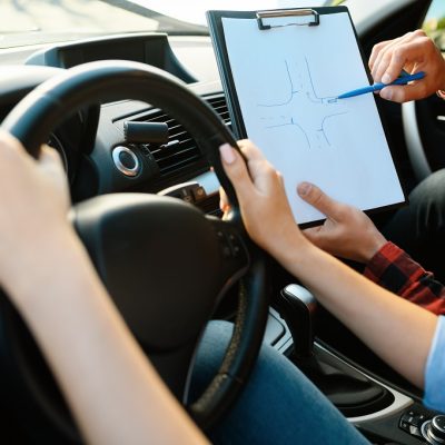 Woman and man with checklist, driving school
