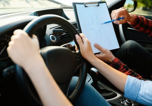 Woman and man with checklist, driving school